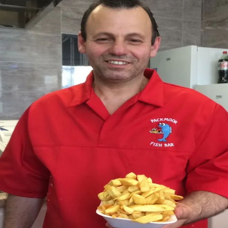 Packmoor Fish Bar owner holding tray of fresh chips in red shirt